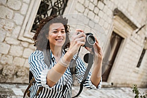 Tourist walking on the street in european old city using camera