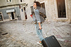 Tourist walking with suitcase on the street in european old city