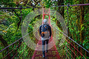 Tourist walking on a suspension bridge in Monteverde Cloud Forest, Costa Rica