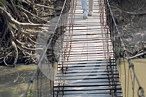 Tourist walking on a suspension wooden bridge