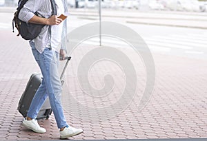 Tourist walking to transportation stop with luggage