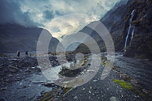 Tourist walking on trail to franz josef glacier in foggy weather