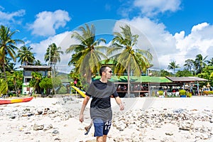 A tourist walks along a sandy tropical beach. Typical vacationer