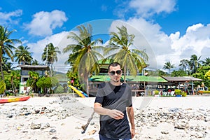 A tourist walks along a sandy tropical beach. Typical vacationer photo