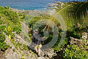 A tourist walks down a path in Niue