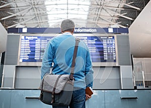 Tourist is watching electronic board in terminal