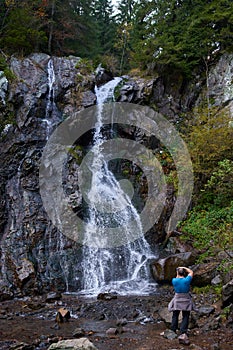 Tourist by the waterfall