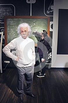 A tourist in the Wax museum Madame Tussauds with the statue of Albert Einstein.