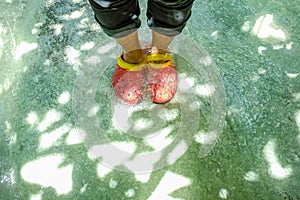 Tourist wear red shoes stang on the clear water in erawan waterfall national park photo