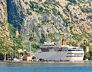 Tourist white cruise sea liner is sailing on the mountain background