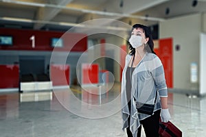 Tourist in a white face mask in a check-in terminal