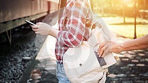 The tourist who were playing mobile phones, she is being tickled by a thief to steal her wallet at the train station. be careful photo