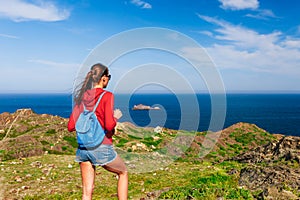 Tourist woman with backpack on Cap de Creus, natural park. Eastern point of Spain, Girona province, Catalonia. Famous tourist