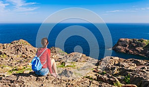 Tourist woman with backpack on Cap de Creus, natural park. Eastern point of Spain, Girona province, Catalonia. Famous tourist