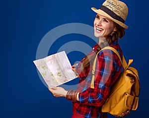 Tourist woman on blue background with map looking into distance