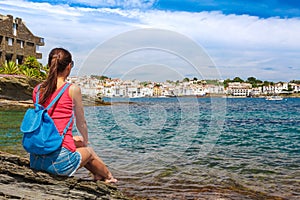 Tourist woman in Cadaques, Catalonia, Spain near of Barcelona. Scenic old town with nice beach and clear blue water in bay. Famous