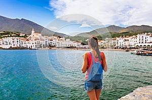 Tourist woman in Cadaques, Catalonia, Spain near of Barcelona. Scenic old town with nice beach and clear blue water in bay. Famous