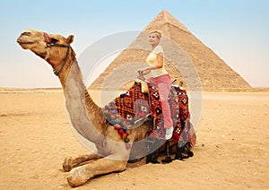 Tourist woman on camel in Giza. Young blonde near Pyramid