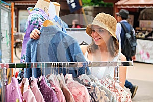 Tourist woman choosing a kimono at a Japanese street shop in Tokyo.