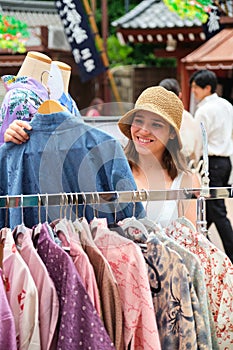 Tourist woman choosing a kimono at a Japanese street shop in Tokyo.