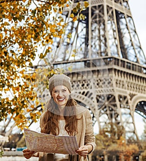 Tourist woman on embankment near Eiffel tower in Paris with map