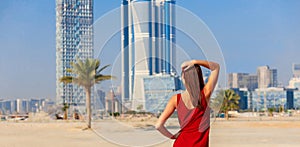 Tourist woman enjoying view of Dubai with palms and skyscrapers from the desert. Sunny summer day in Dubai desert. Dubai is famous