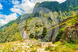 Tourist woman enjoying the view of old fortress and mountains Kotor Montenegro