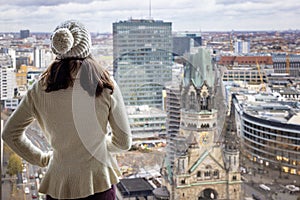 A tourist woman enjoys the panoramic view over the skyline of Berlin