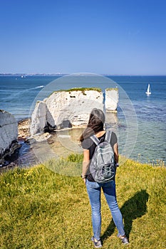 A tourist woman enjoys the view of the Old Harry Rocks in Dorset