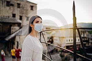 Tourist woman with face mask travelling to European cities during coronavirus pandemic outbreak.Travel to Europe amid COVID-19.