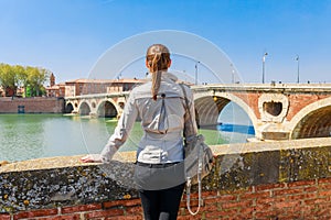 Tourist woman in French ancient town Toulouse and Garonne river. Toulouse is the capital of Haute Garonne department and Occitanie