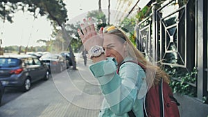 Tourist woman gesturing come along follow me, waving and hand looking at camera on the streets of europe, spain in slow