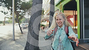 Tourist woman gesturing come along follow me, waving and hand looking at camera on the streets of europe, spain in slow