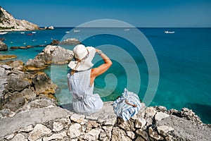 A tourist woman with hat enjoy ionian sea in Agios Nikitas village, Lefkas Island, Greece