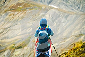 Tourist woman hiker with backpack on mountains viewpoint take photo of scenery in Racha, Georgian region. Udziro lake hiking trail