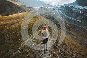 Tourist woman hiking alone in mountains travel adventure vacations