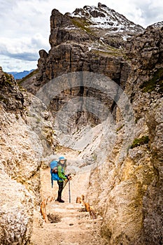 Tourist woman hiking mountain alpine canyon trail cliffs, South Tyrol, Italy