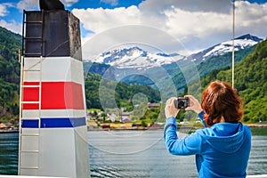 Tourist woman on liner taking photo, Norway