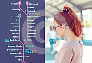 Tourist woman looking at the map of Stockholm metro