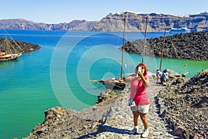 Tourist woman at Nea Kameni volcanic island port Santorini Caldera Greece