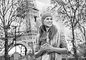 Tourist woman near Eiffel tower with cellphone looking aside