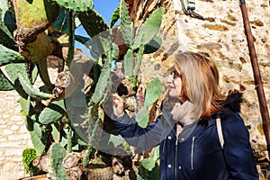 Tourist woman observing a large cactus in the town of Madrid, Patones de Arriba. photo
