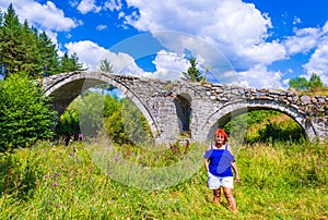 Tourist woman on old bridge Rhodope mountains Bulgaria