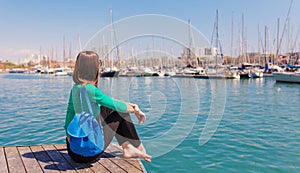 Tourist woman in the port of Barcelona, Catalonia, Spain. Scenic seascape of marina and sailboats yachts. Public promenade and