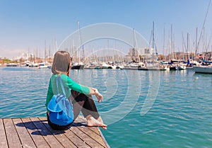 Tourist woman in the port of Barcelona, Catalonia, Spain. Scenic seascape of marina and sailboats yachts. Public promenade and
