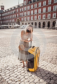 Tourist woman with protective face mask in Spain worried about travel restrictions and quarantine