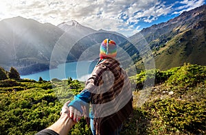 Tourist woman in rainbow hat at the mountains