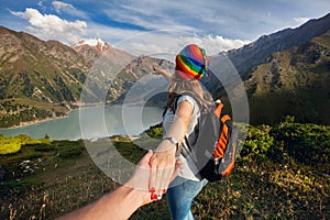 Tourist woman in rainbow hat at the mountains