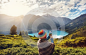 Tourist woman in rainbow hat at the mountains