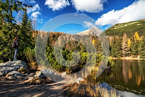 Tourist woman on the shore of mountain lake Jamske pleso in High Tatras mountains in Slovakia